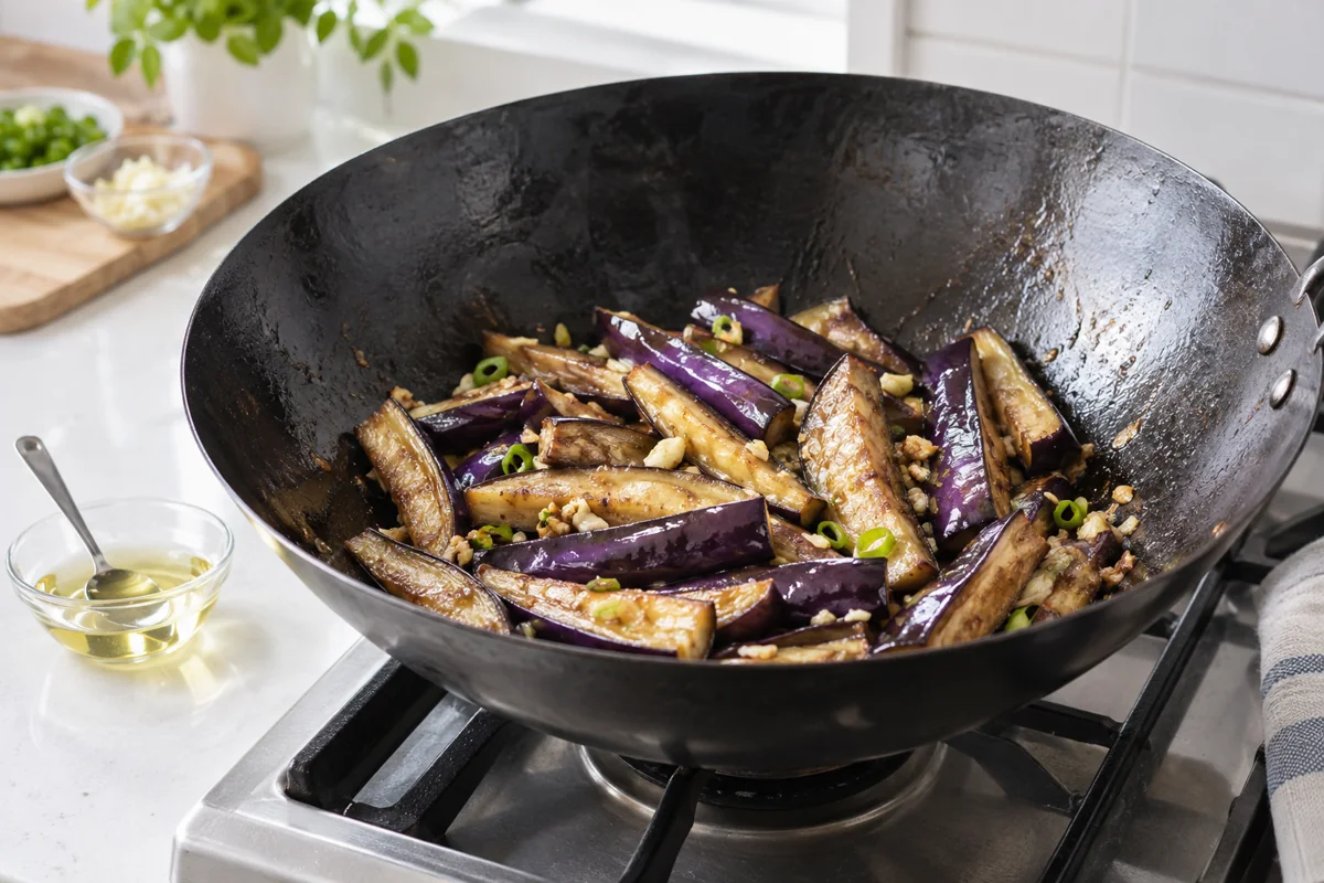 Long purple eggplant wedges with a modest oil measure beside the wok Long purple eggplant wedges with a modest oil measure beside the wok